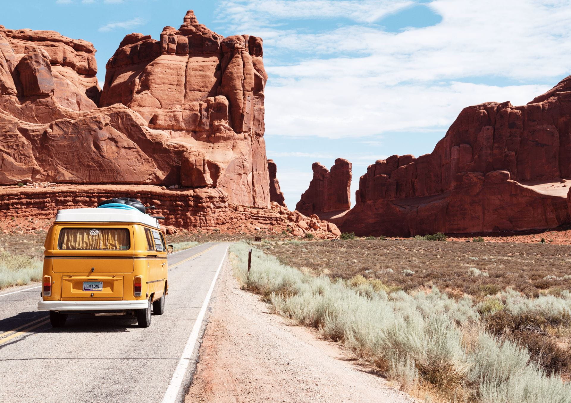yellow van driving on desert road